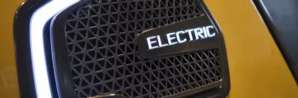 Nahaufnahme eines Kühlergrills eines Elektrofahrzeugs mit beleuchtetem 