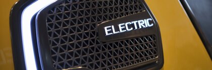 Close-up of a radiator grille of an electric vehicle with illuminated 