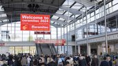 Menschenmenge am Eingang Messe München, ceramitec 2024 in einer großen Halle mit Glasdach und einem einladenden Banner darüber.
