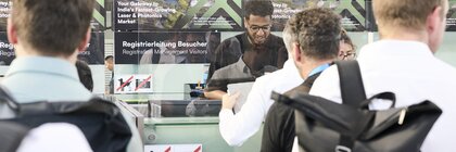 Besucher bei der Registrierung und dem Einlass zu einer Fachmesse im Eingangsbereich der Messe München.