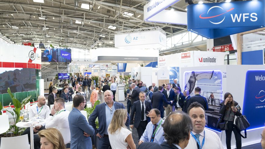 Numerous visitors at transport logistic with various stands and banners in an exhibition hall at Messe München.