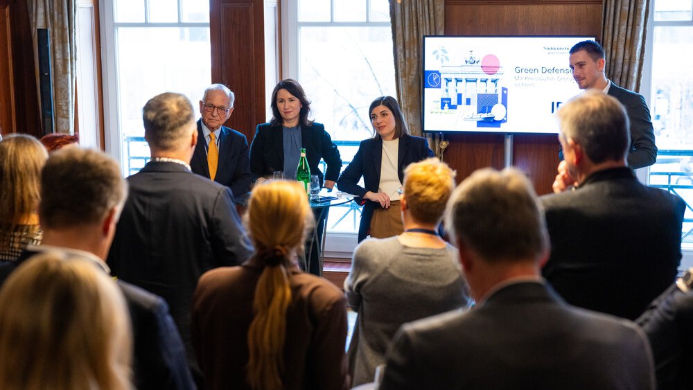 Gut besuchte Lunchsession zu „Green Defense“ auf dem Gipfel: Vor Publikum stehen (von links nach rechts) Wolfgang Ischinger, Anja Siegesmund, Nakissa Salavati und Philipp Eisenmann an einem Stehtisch im Gespräch. 
