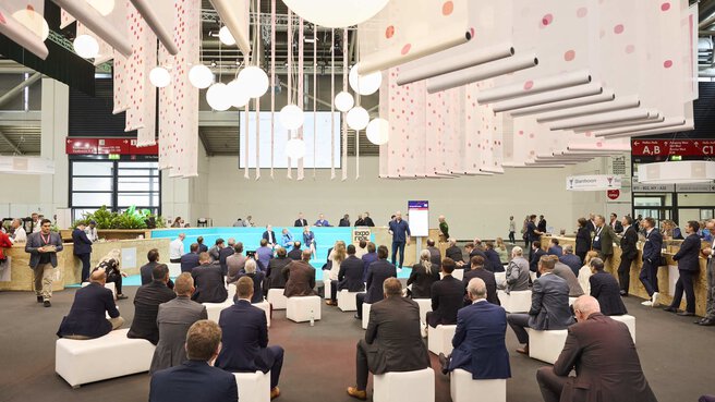 Audience on white seating cubes in front of the 