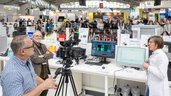 A camera crew is filming a live demonstration at a laboratory workstation