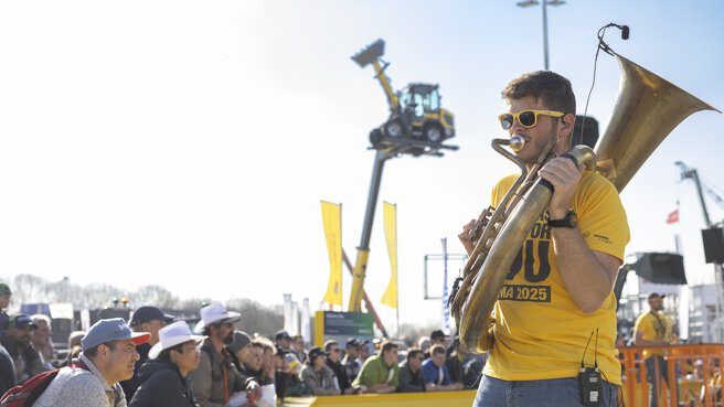 Musiker mit Blasinstrument auf Live-Demonstration. Im Hintergrund sieht man Zuschauer.