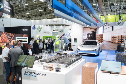 Exhibition stand with an exhibit illustrating various components of automotive recycling.