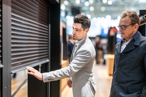 An exhibitor is explaining how a blind works.