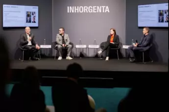 Four panellists sit on a stage at an INHORGENTA event and speak to the audience.