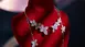 A flower necklace with diamonds, presented on a red velvet mannequin against a dark background.