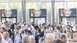 A large crowd at automatica 2023 in a closed room with visible banners in the background pointing to automatica 2025.