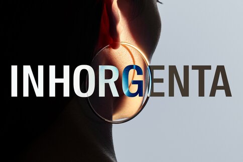 The INHORGENTA logo in front of a close-up of a round earring worn by a woman.