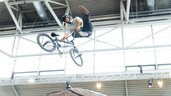 Junge springt über Schanze mit Fahrrad