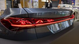 Nahaufnahme von der roten länglichen Beleuchtung eines grauen Autohecks an einem Stand auf der LOPEC Messe.