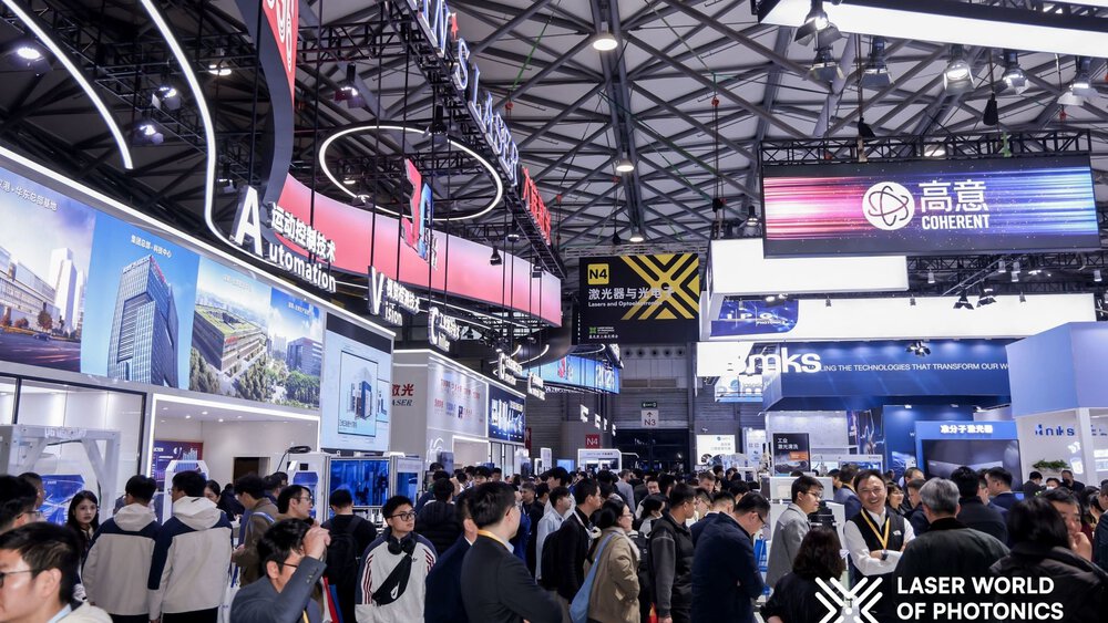 Blick in eine Halle der Laser World of Photonics Shanghai mit vielen bunten Messeständen und zahlreichen Besuchern, die sich informieren.
