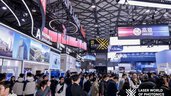 Blick in eine Halle der Laser World of Photonics Shanghai mit vielen bunten Messeständen und zahlreichen Besuchern, die sich informieren.