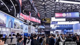 Blick in eine Halle der Laser World of Photonics Shanghai mit vielen bunten Messeständen und zahlreichen Besuchern, die sich informieren.
