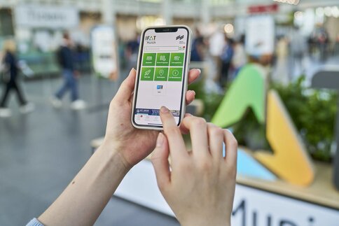 Bild von einem Handy mit der IFAT Munich App auf dem Bildschirm.