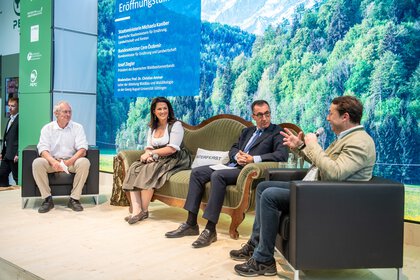 Diskussionsrunde von Personen auf der grünen Coach