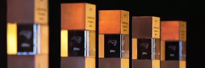 Row of slim, rectangular display cases with awards against a dark background. The focus is on the ‘productronica innovation award 2017’.