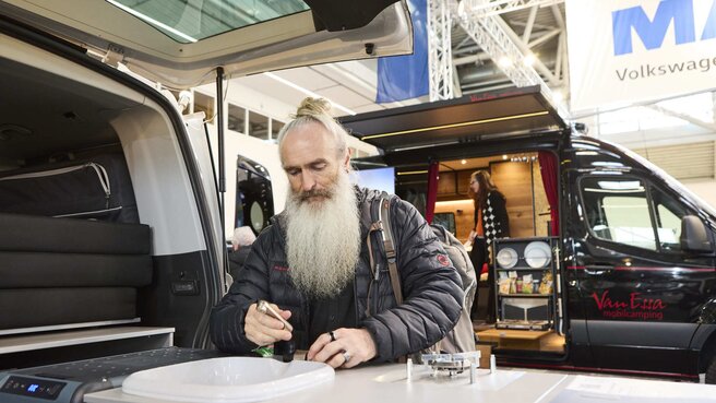 Ein Besucher inspiziert verschiedene Caravane auf der Messe f.re.e 2025 und entdeckt verschiedene Modelle.