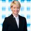 A smiling woman in a suit, with short blonde hair.