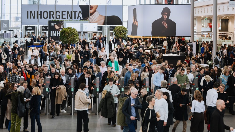 The busy entrance area of the INHORGENTA trade fair, with large advertising banners in the background and visitors in front of and behind the ticket barriers.