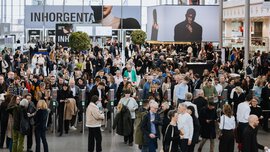 The busy entrance area of the INHORGENTA trade fair, with large advertising banners in the background and visitors in front of and behind the ticket barriers.