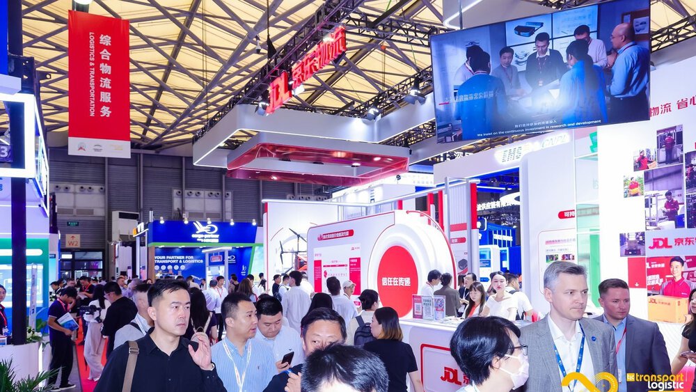In an event hall, numerous visitors walk around between exhibition stands at 