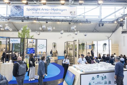 Hydrogen and circular economy stand at IFAT Munich with visitors and information displays.