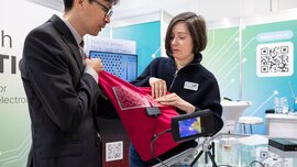 Demonstration of a textile-integrated heating element with a thermal camera at a LOPEC booth