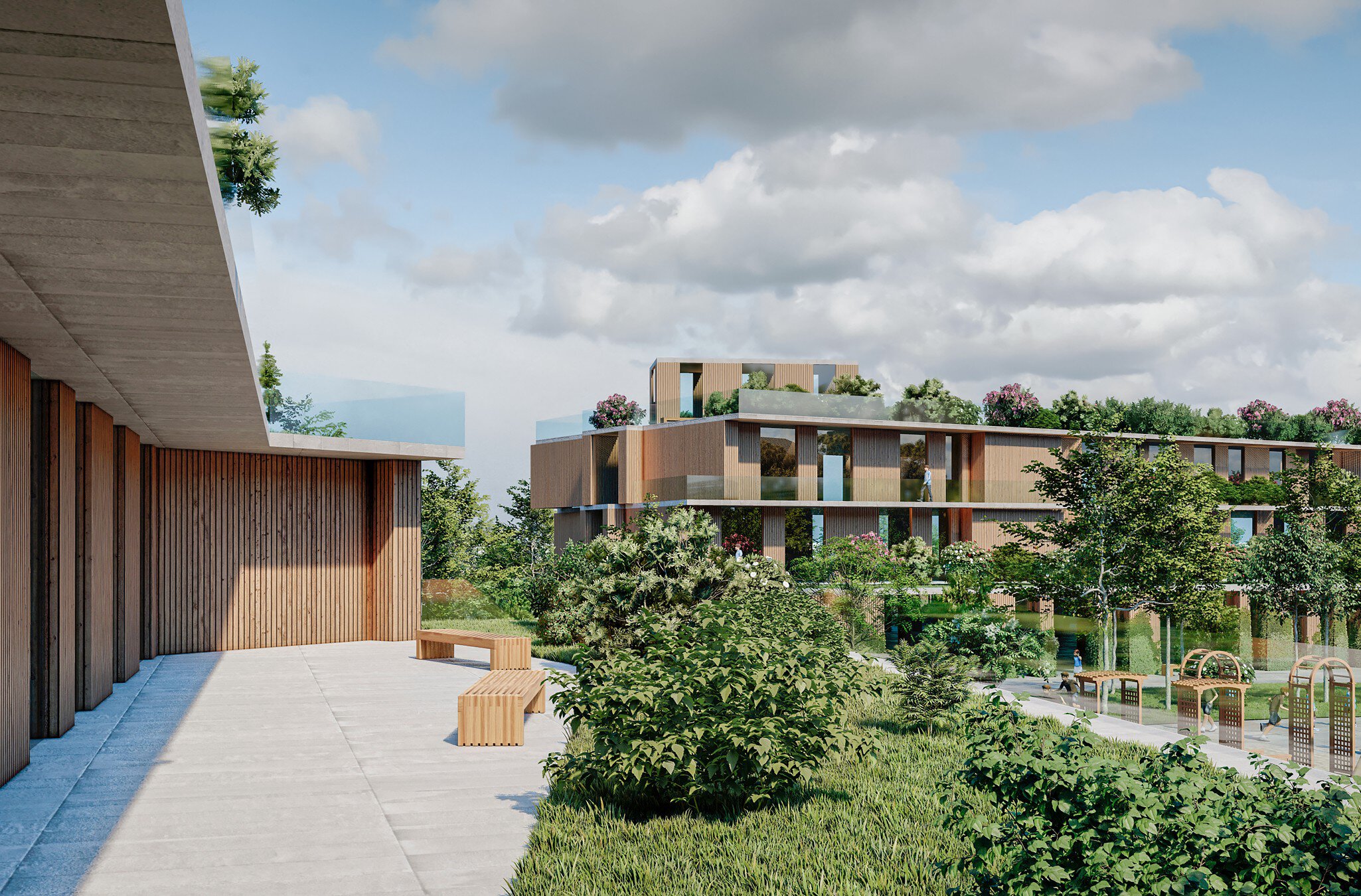 Zwei moderne eckige Gebäudekomplexe mit Holzfassaden, umgeben von viel Grün und Bäumen unter einem teilweise bewölkten Himmel.
