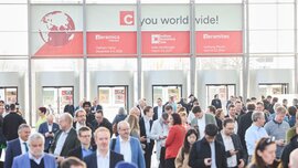 Crowds of visitors in the exhibition entrance area with ceramitec signage.