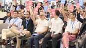 Teilnehmende stimmen beim Pitch-Wettbewerb im Founders Forum der World of Quantum 2025 aktiv mit farbigen Karten ab.