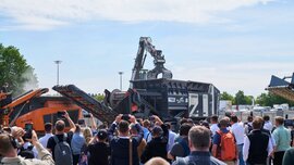 A group of spectators photographing and filming a live demonstration of mobile recycling shredders in the IFAT outdoor area.