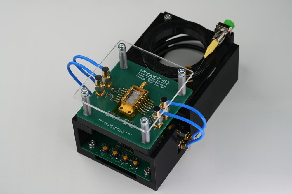 Photonik-Demonstrator von PhoenixD mit optischer Chipintegration, grüner Platine und blauen Anschlussleitungen