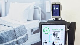Hospital robots with digital face display and touchscreen in a modern medical environment.