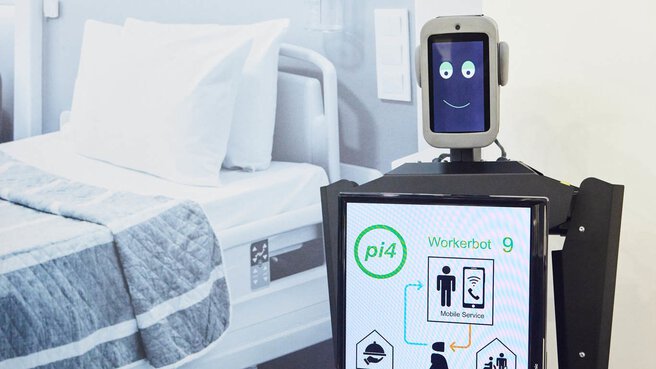 Krankenhausroboter mit digitaler Gesichtsanzeige und Touchscreen in einer modernen medizinischen Umgebung.
