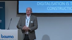 Ein Mann im Anzug hält einen Vortrag über Digitalisierung im Bauwesen.