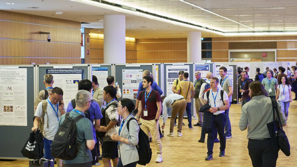 People looking at a series of information posters on display in a large hall.