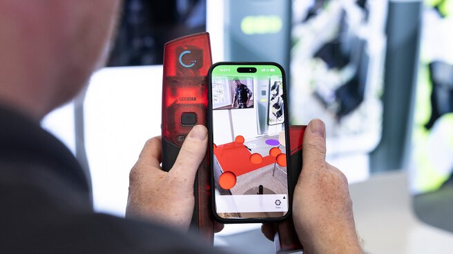 Ein Mann hält ein Smartphone mit augmented Reality Inhalten.