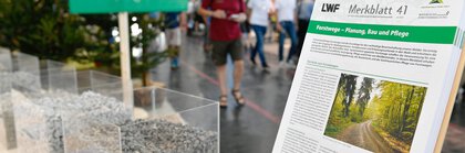  Focus on a pile of leaflets at the stand of the Bavarian State Institute for Forestry and Forest Economics, next to transparent containers with different types of gravel.