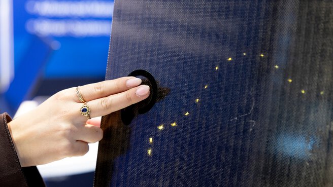 Hand berührt interaktive Oberfläche mit integrierten Leuchtpunkten aus gedruckter Elektronik