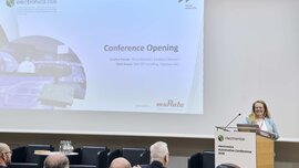 A woman speaks on stage during the opening of the electronica Automotive Conference 2025.