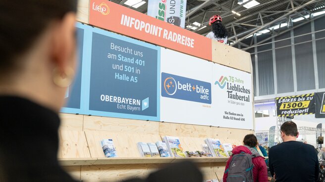 Besucher betrachten einen Stand mit Informationen und Radreiseangeboten.