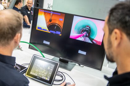 A monitor displaying two endoscopic images in an industrial setting.