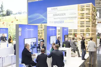 Lebendiges Treiben auf der Weltleitmesse zum Thema Wasser- und Abwasserwirtschaft IFAT Munich. Das Bild zeigt einen Stand mit mehreren Infopoints. An den einzelnen Infopoints informieren sich zahlreiche Besucher und nutzen die Gelegenheit zum Networking. Im Hintergrund sieht man große die Schlagworte „Kanal“, „Abwasser“, Industrieabwasserreinigung“, „Kläranlagen“ und „Wasser“. Über den Ständen sind Schilder von Ausstellern wie „hanseWasser“, „Gelsenwasser“ „EasyMining“ und anderen Unternehmen der Wasserbranche zu sehen.