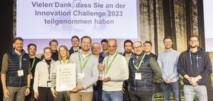 Eine Gruppe von Menschen mit Gewinner-Urkunde und Trophäe der 