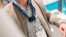 Tragbares Medizingerät mit Elektroden und Ausweishalter in Nahaufnahme an einem DMEA-Stand