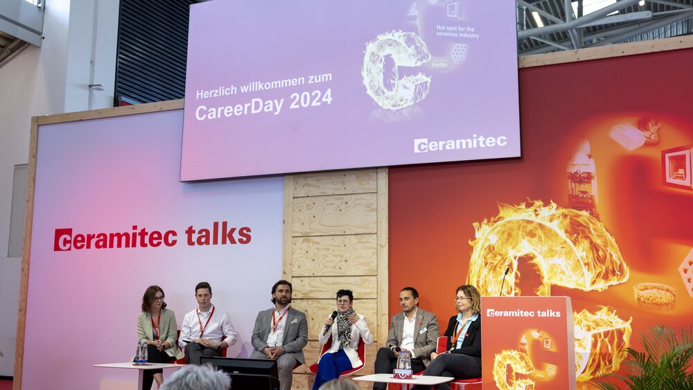 A stage with six speakers with a large screen on which 