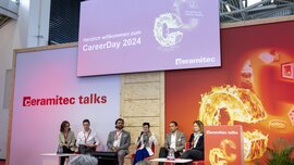 A stage with six speakers with a large screen on which 